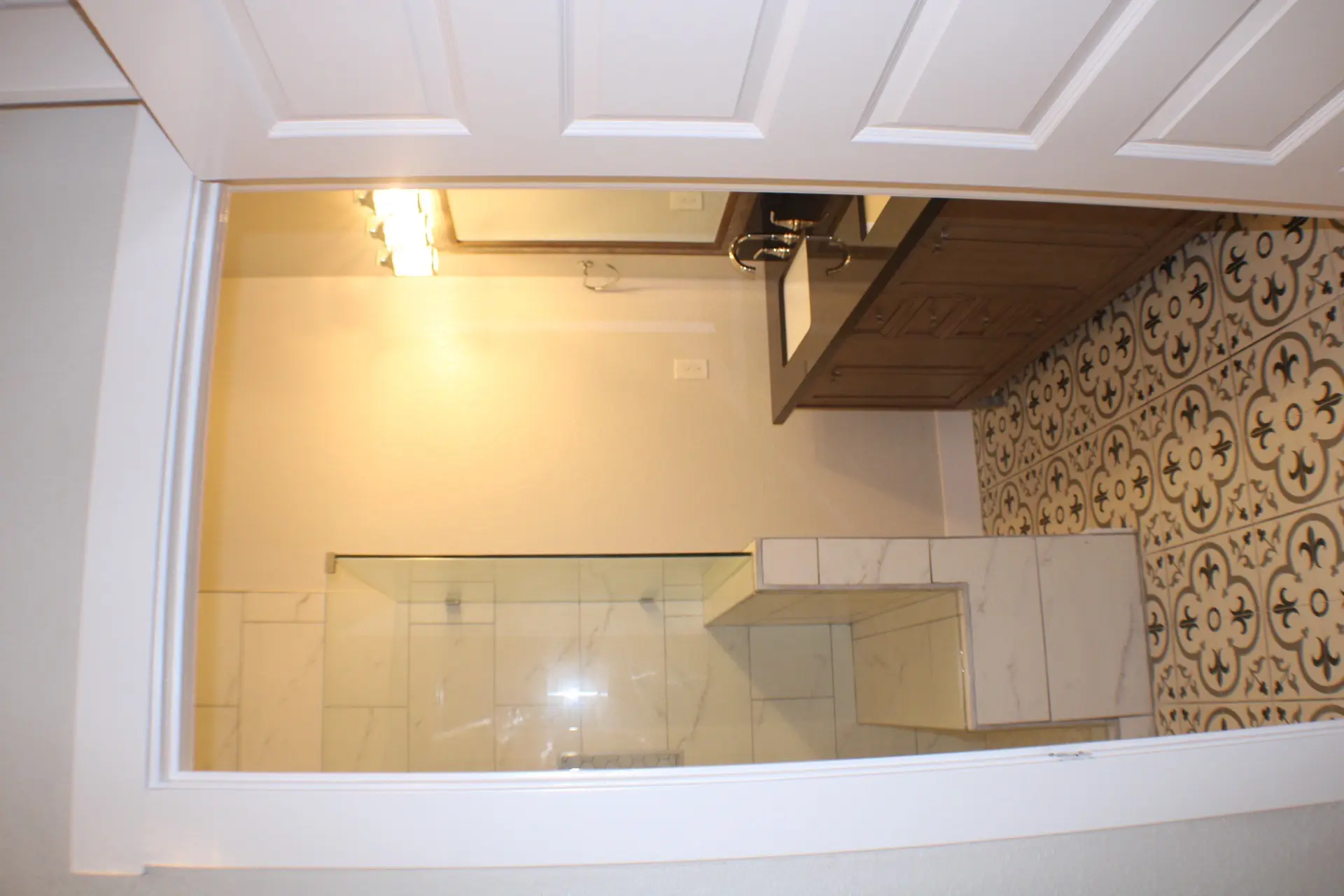Kitchen and dining view showing the navy island centerpiece, white cabinetry, modern pendant lights, and open-concept layout in the Marina District cottage