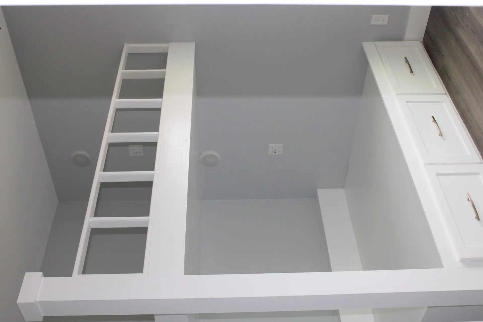 Primary shower interior showing floor-to-ceiling marble-look wall tile, recessed niche shelf, and frameless glass door with chrome hardware