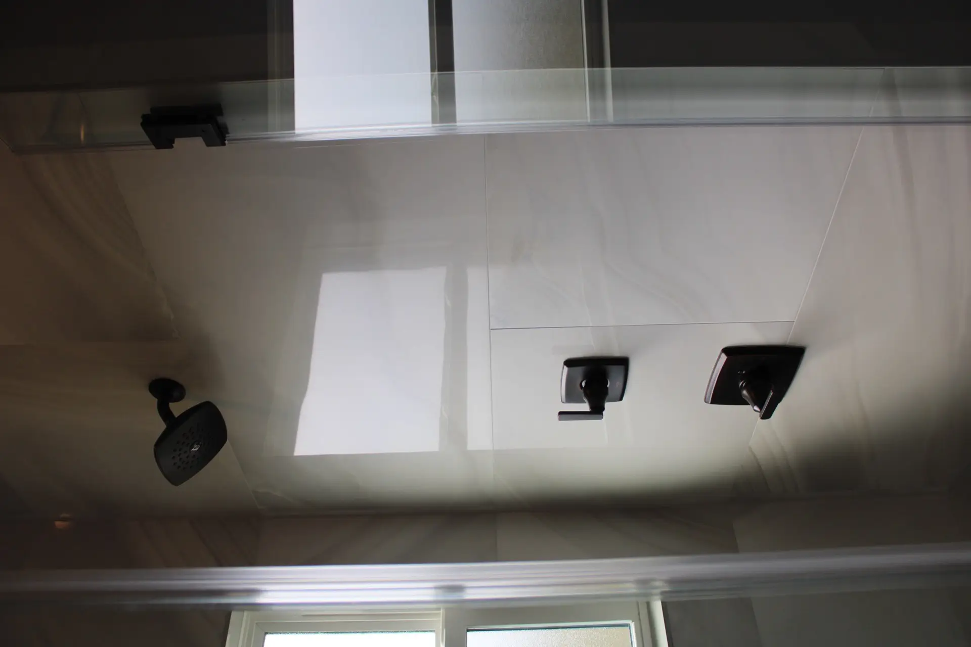 Stairwell looking down from the upper level showing the metal railing system, white walls, and dark plank flooring on each tread
