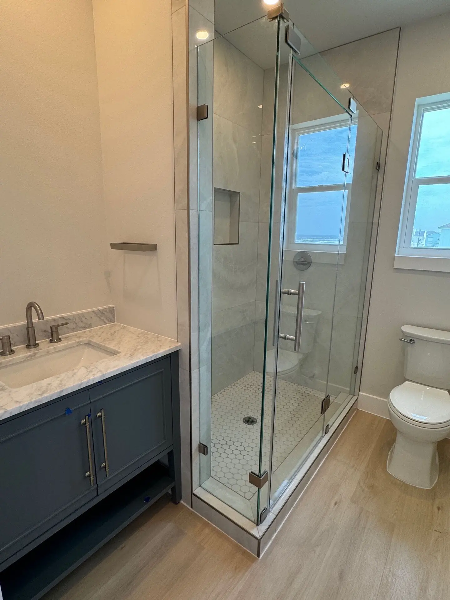 Second-floor guest bedroom with sliding glass doors to the wraparound porch and unobstructed water views beyond
