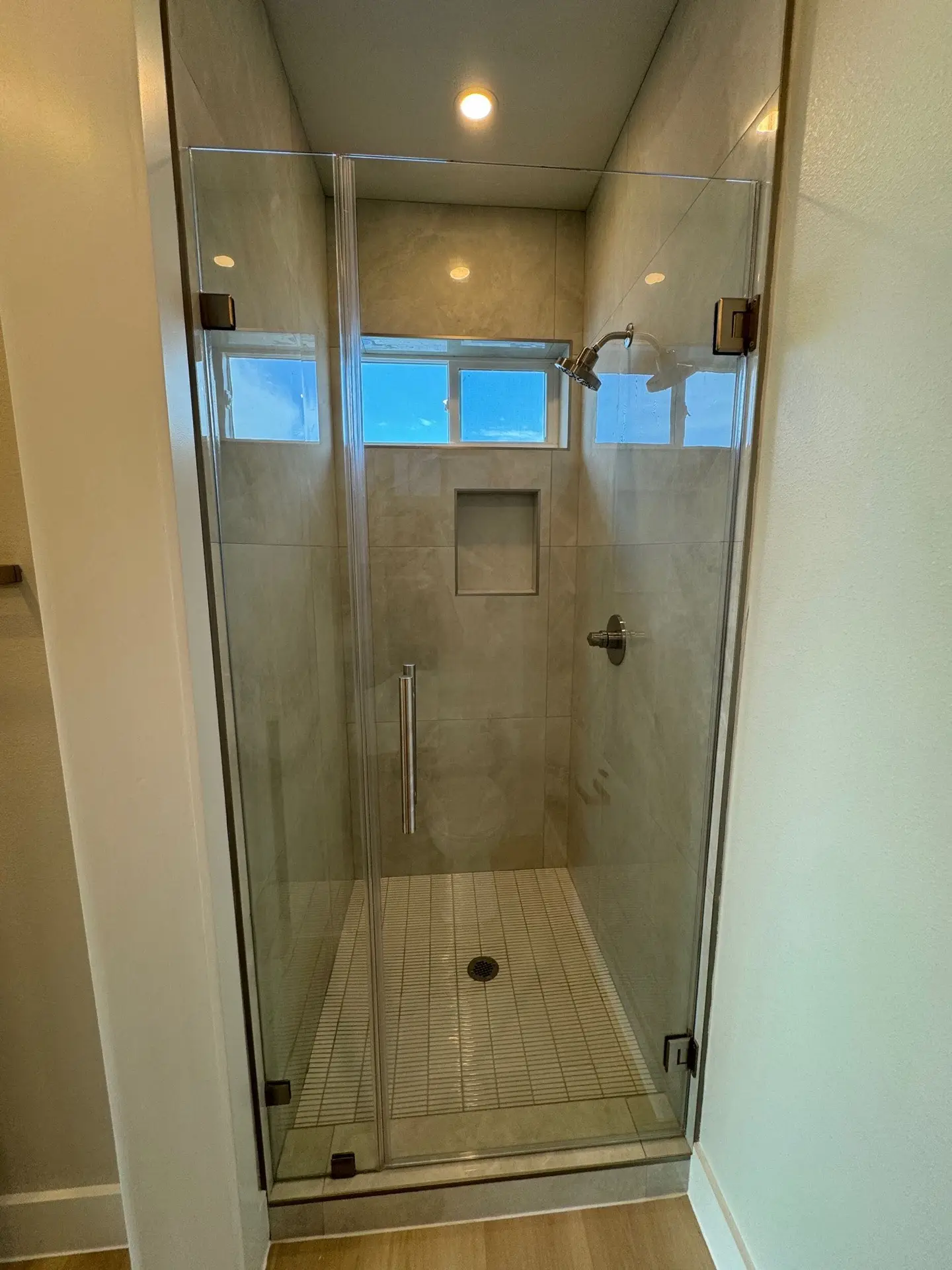 Third bedroom with warm lighting, light hardwood floors, and balcony slider doors for morning Gulf breezes