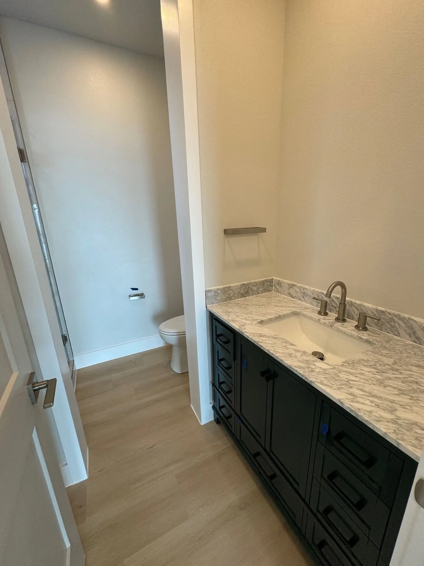 Fifth bedroom tucked on the lower level with comfortable proportions, coastal finishes, and easy porch access