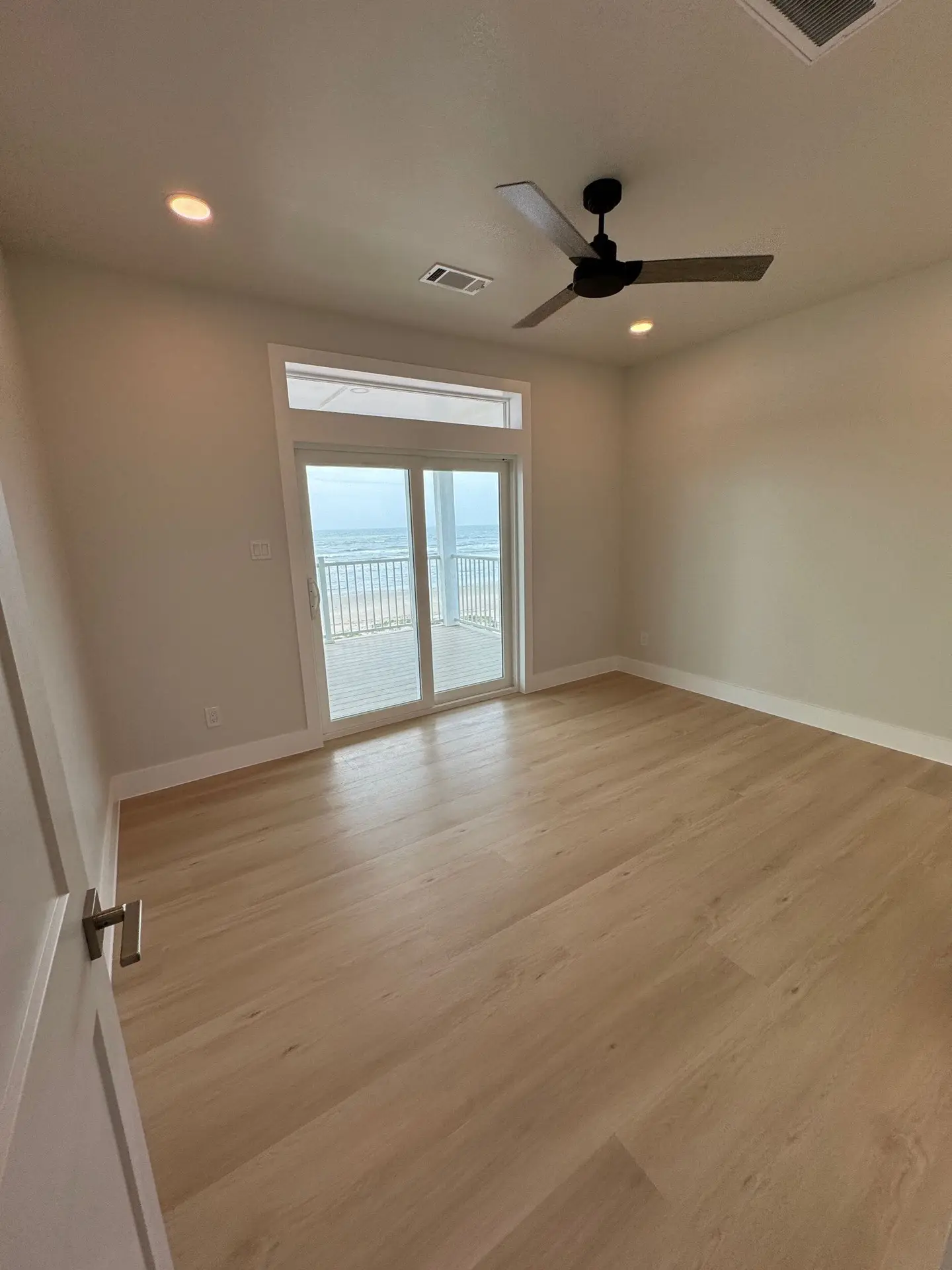Corner porch seating area with Gulf breeze exposure, painted beadboard ceiling, and views down Gulf Drive
