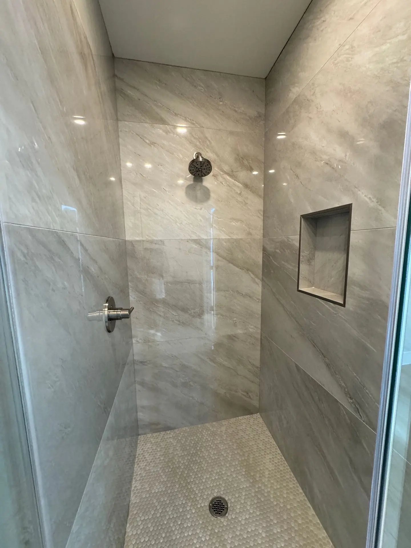 Kitchen island close-up showing white shaker cabinet base with brass pulls and polished countertop under pendant lighting