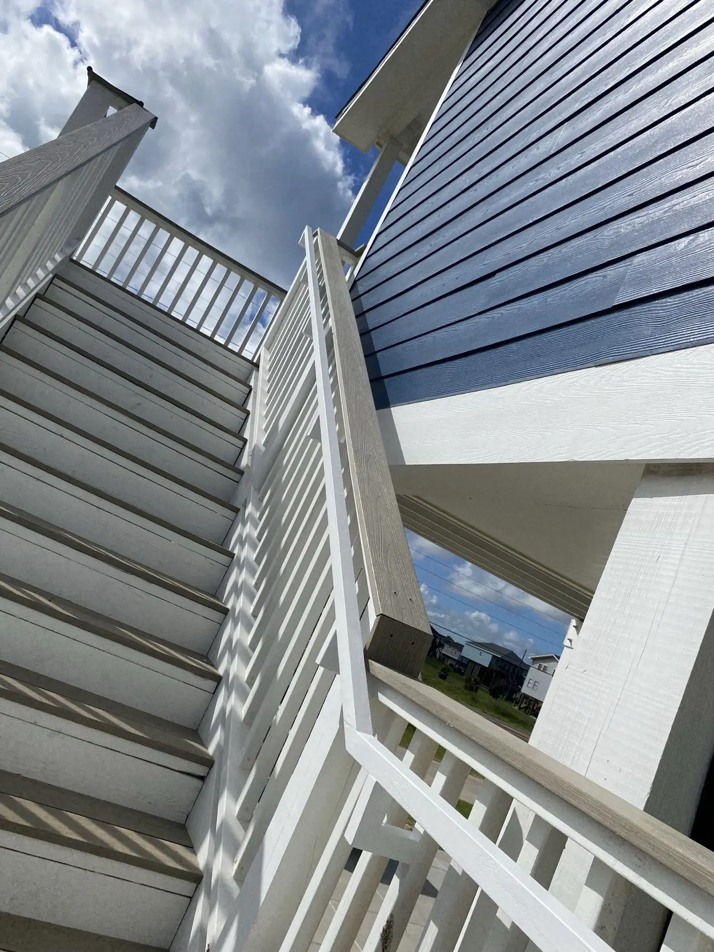 Guest bedroom featuring recessed ceiling detail, modern light fixture, and wide-plank oak hardwood floors at 131 Gulf Drive