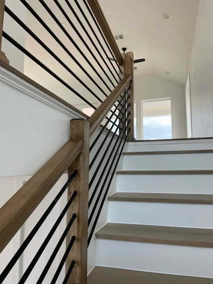 Kitchen island detail showing navy cabinetry with brushed gold hardware, white quartz waterfall edge, and built-in wine rack storage