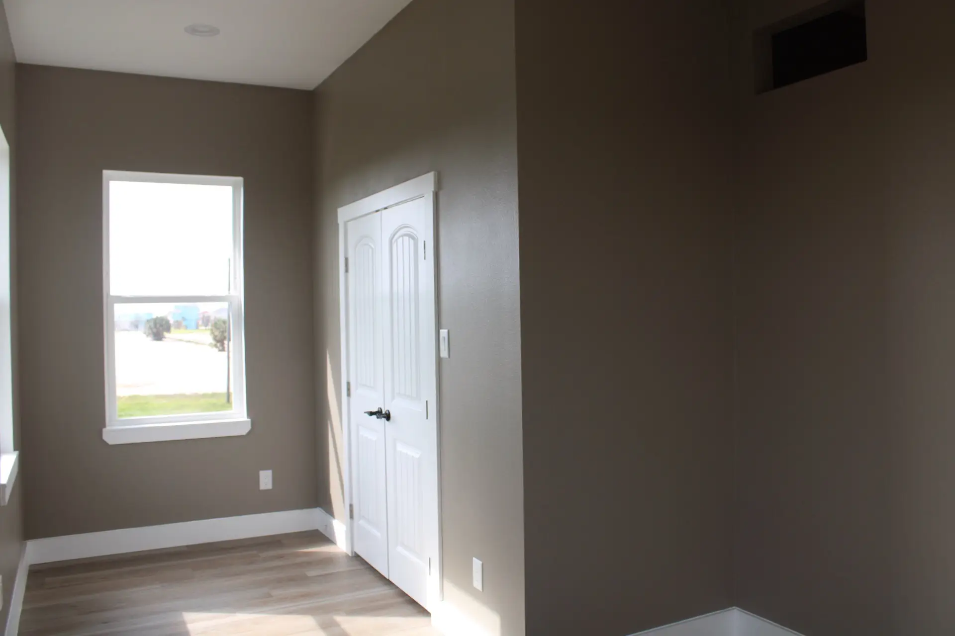 Kitchen island detail showing speckled granite countertop surface, black matte cabinet hardware, and pendant light fixtures above