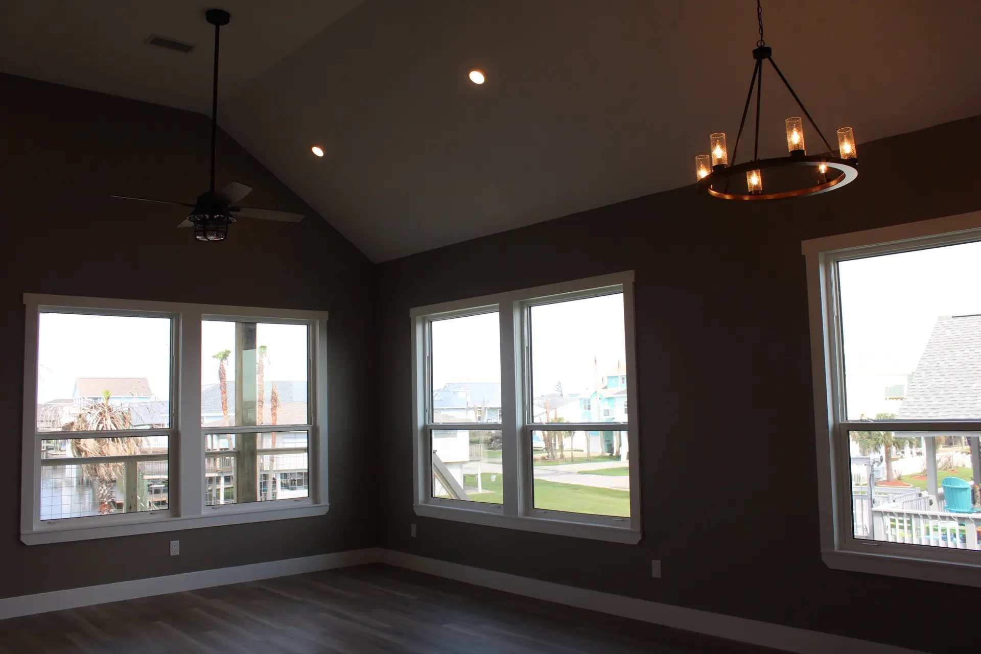 Stone tile backsplash and white shaker upper cabinets with black matte handles flanking the stainless steel range in the Tiki Island kitchen