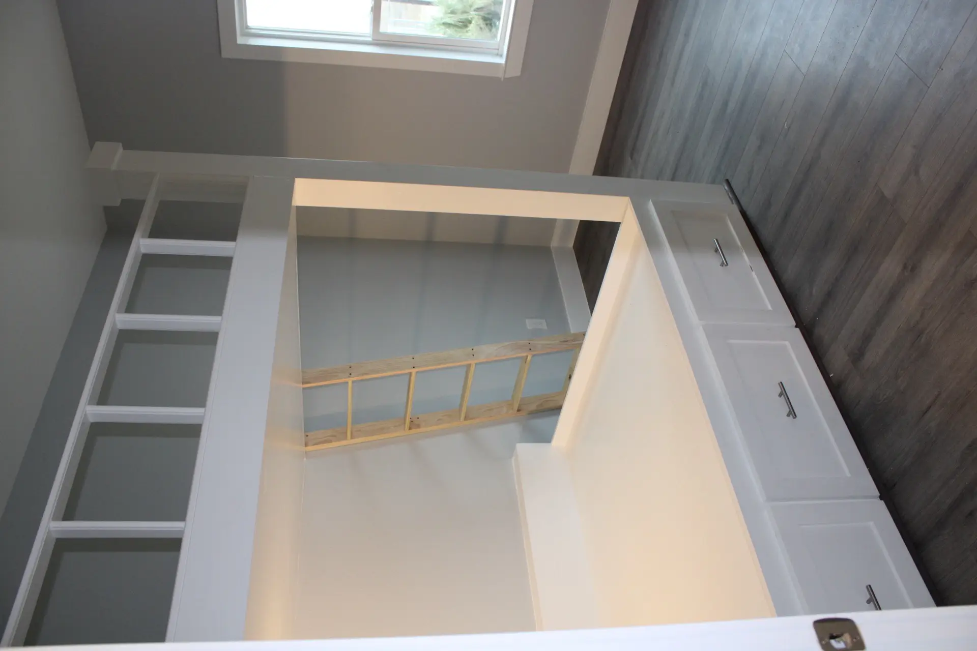 Open-concept kitchen with white shaker cabinets, marble and quartz island countertop, teal striped tile backsplash, and pendant lighting at 31 Laguna