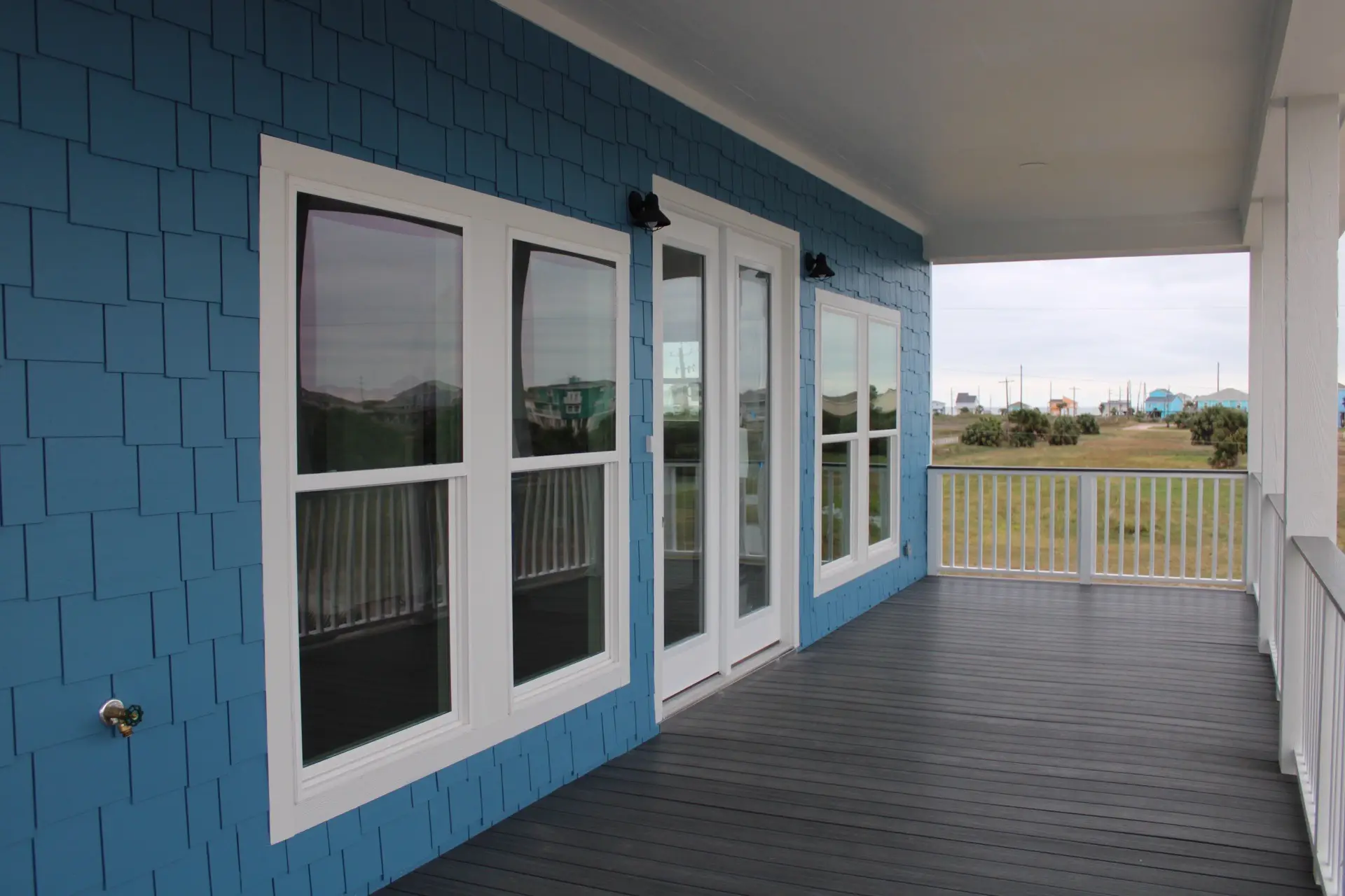 Teal striped tile backsplash detail behind the range, adding bold coastal personality to the white shaker cabinet kitchen