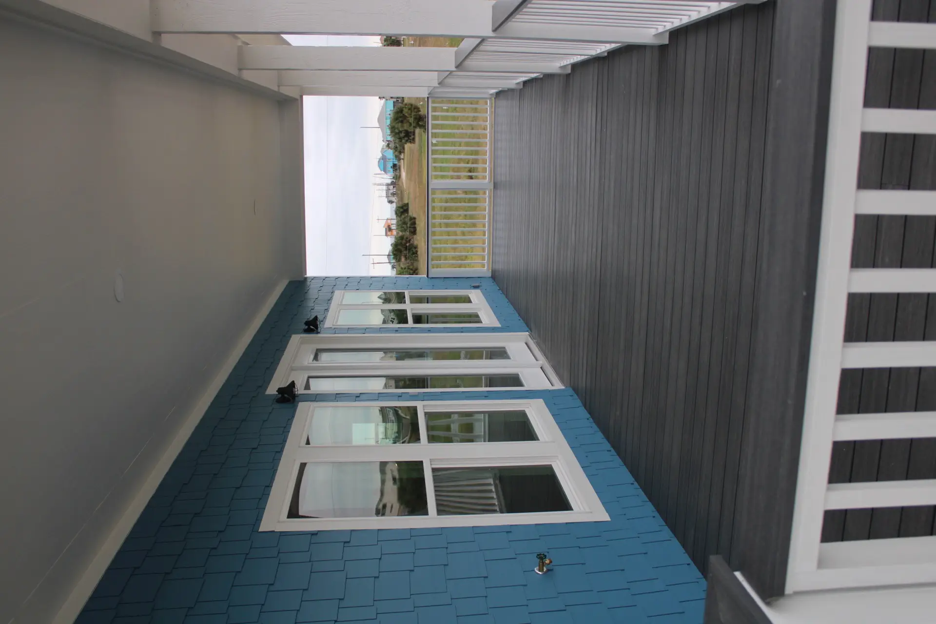Master bedroom with French doors opening to the covered porch, soft blue walls, and natural light flooding the room at 31 Laguna