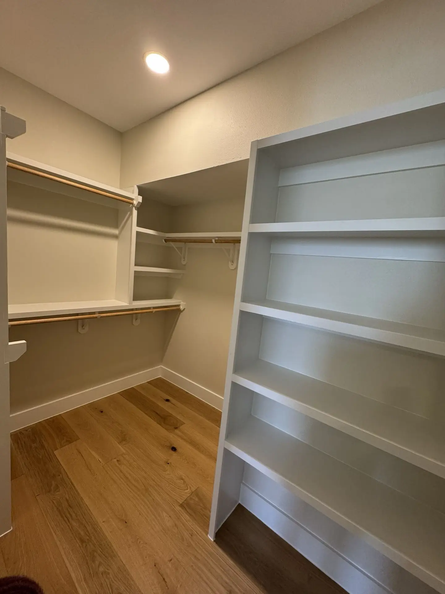 Guest bedroom with oak hardwood flooring, crown molding ceiling detail, and natural light from the West Bay waterfront property